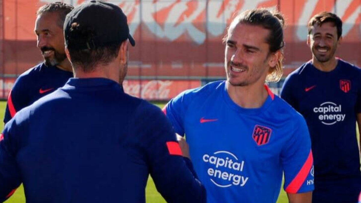 Griezmann, aún sin cortarse el pelo, saluda a Simeone en el entrenamiento de esta mañana.