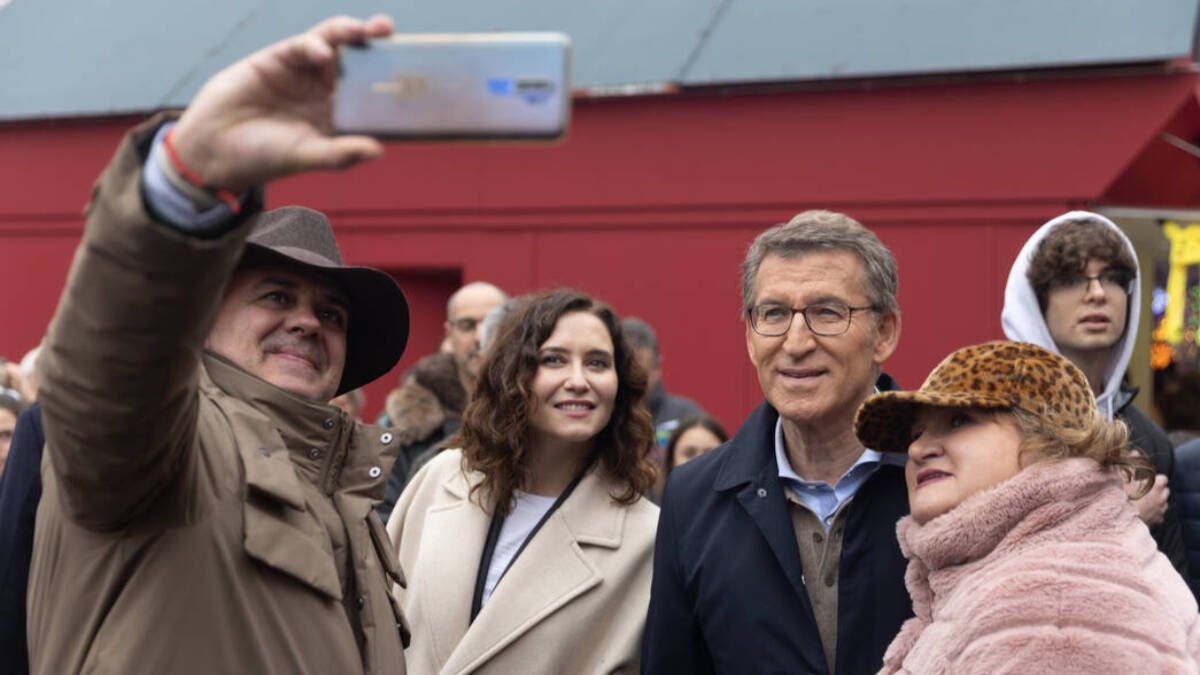 La presidenta de la Comunidad de Madrid, Isabel Díaz Ayuso, y el líder del PP, Alberto Núñez Feijóo, se hacen fotos con simpatizantes durante un paseo por la Plaza Mayor.