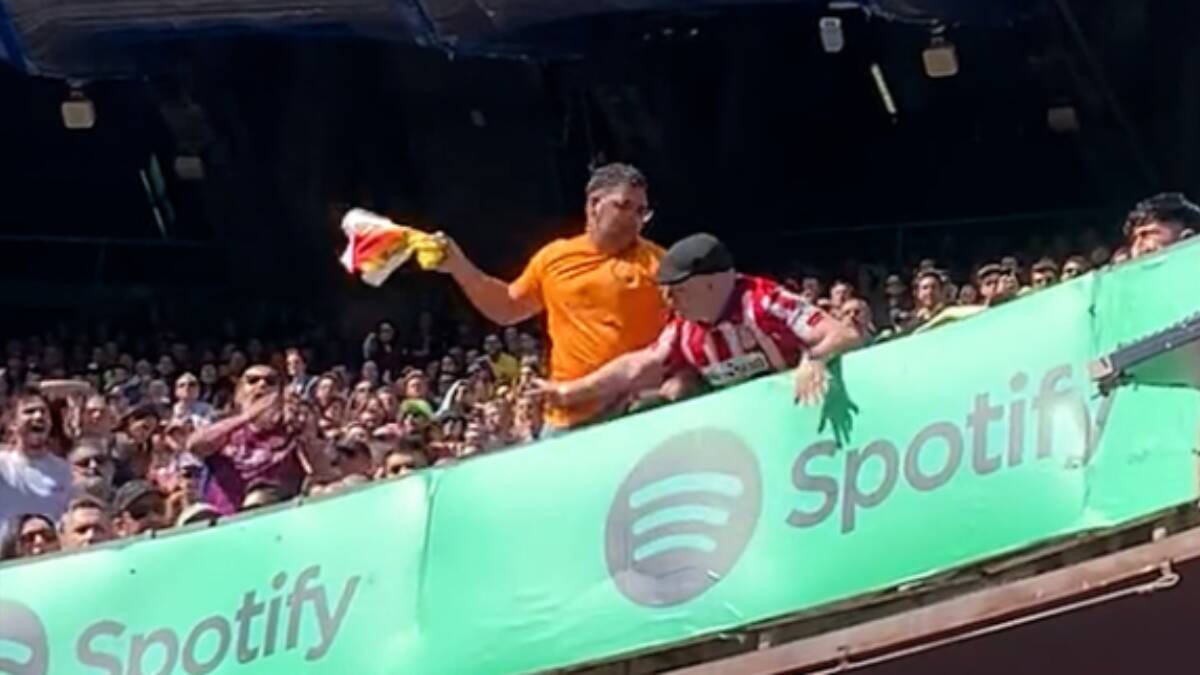 Imagen del momento en el que el aficionado del Barcelona retira la bandera de España con el escudo del Atlético de Madrid.