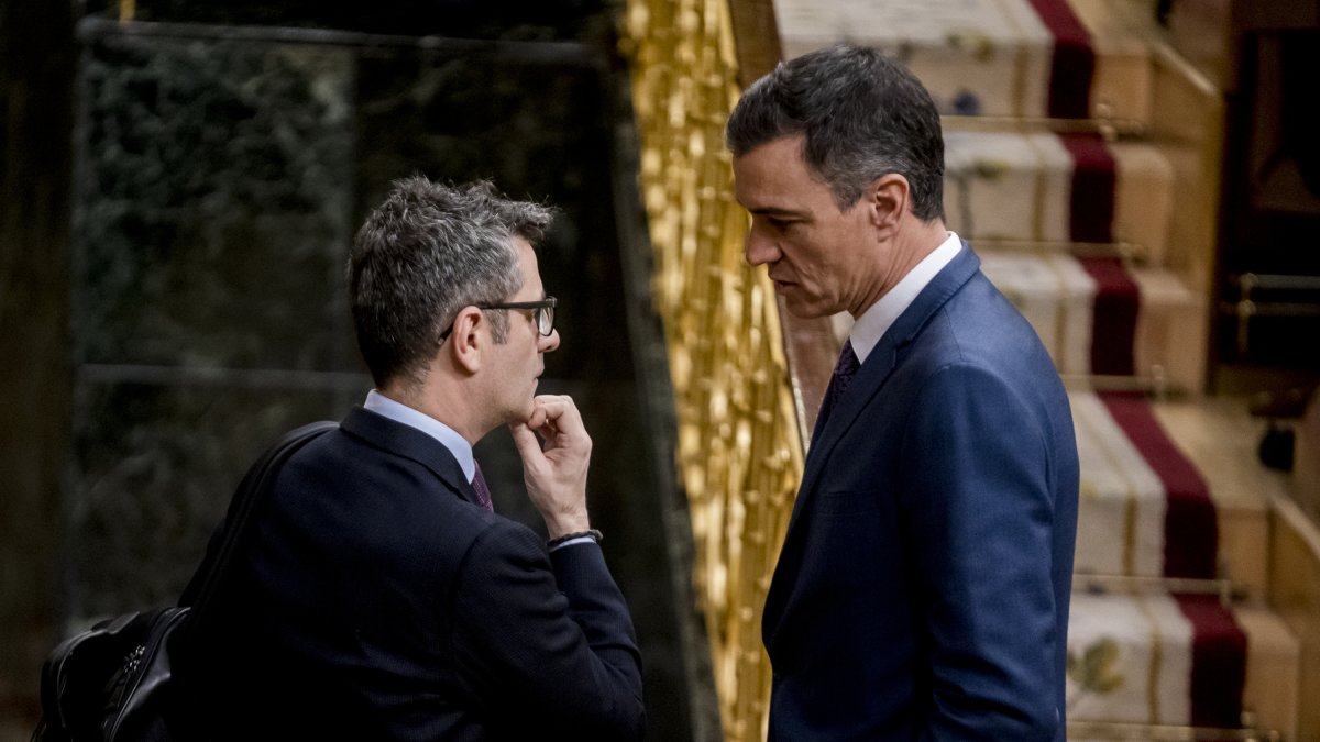 Félix Bolaños y Pedro Sánchez charlan en el Congreso.