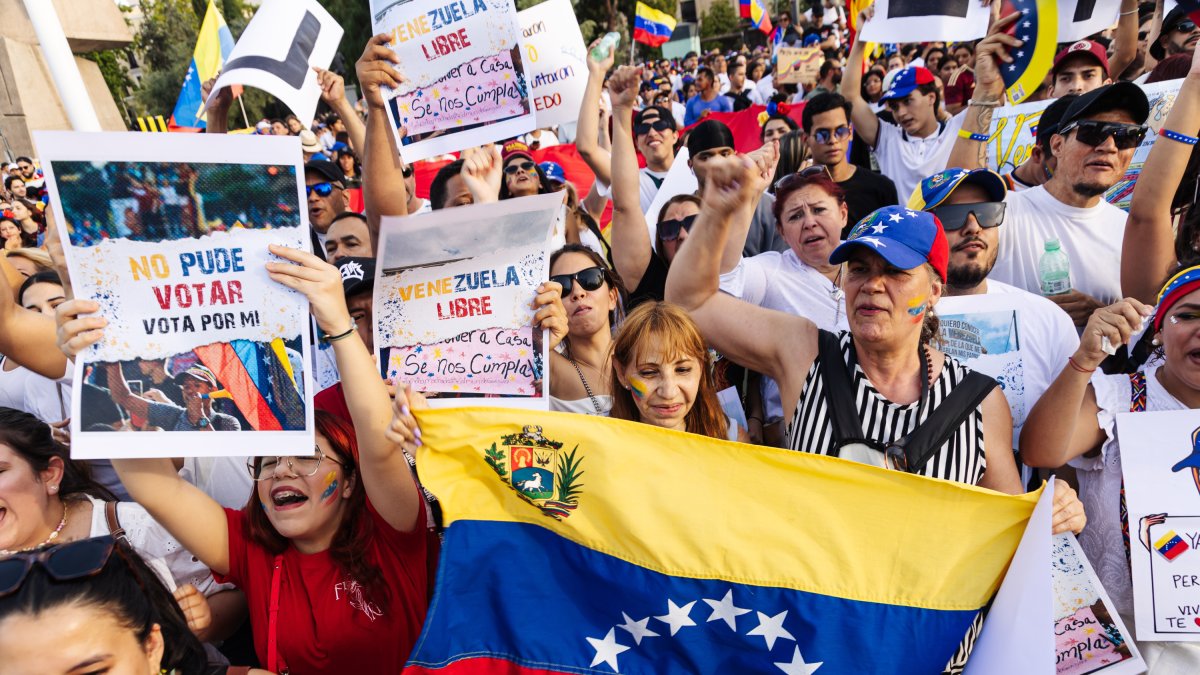 Manifestantes con pancartas durante una protesta en apoyo a la oposición venezolana en Madrid.