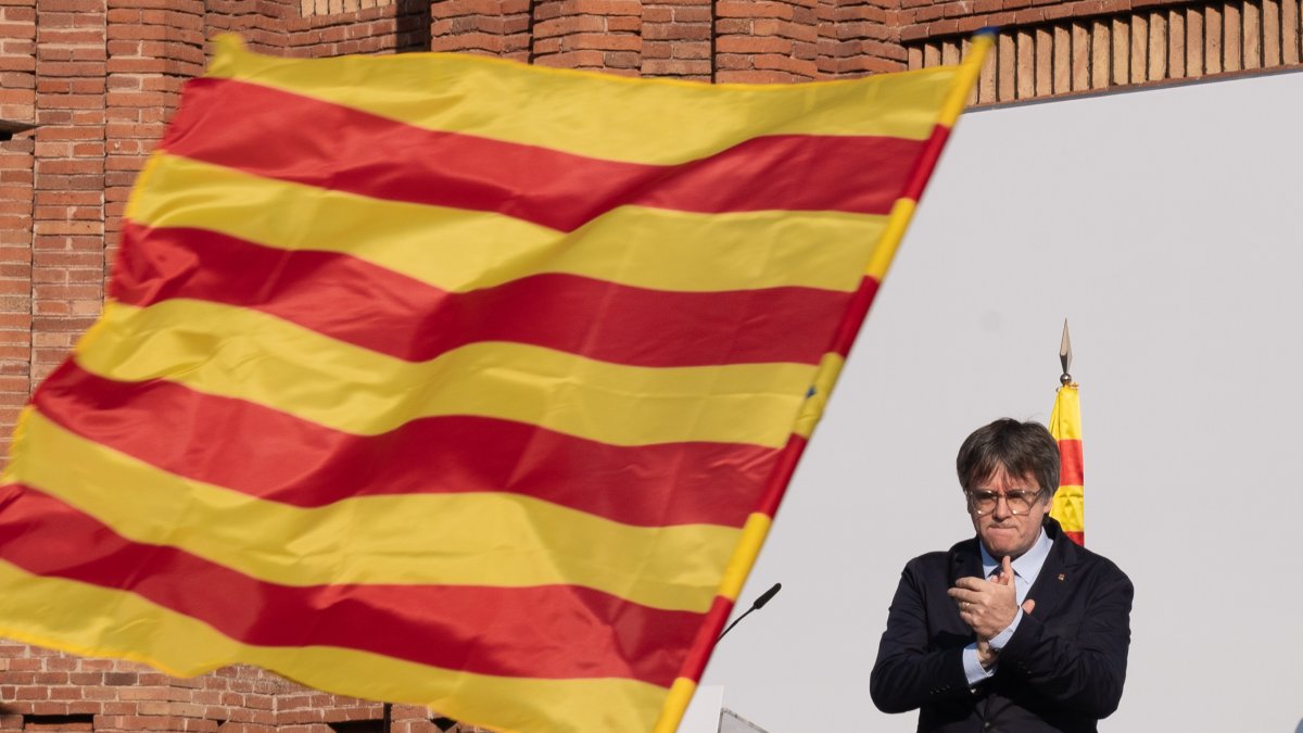 Carles Puigdemont aplaude durante el acto tras el que acabó escapándose.