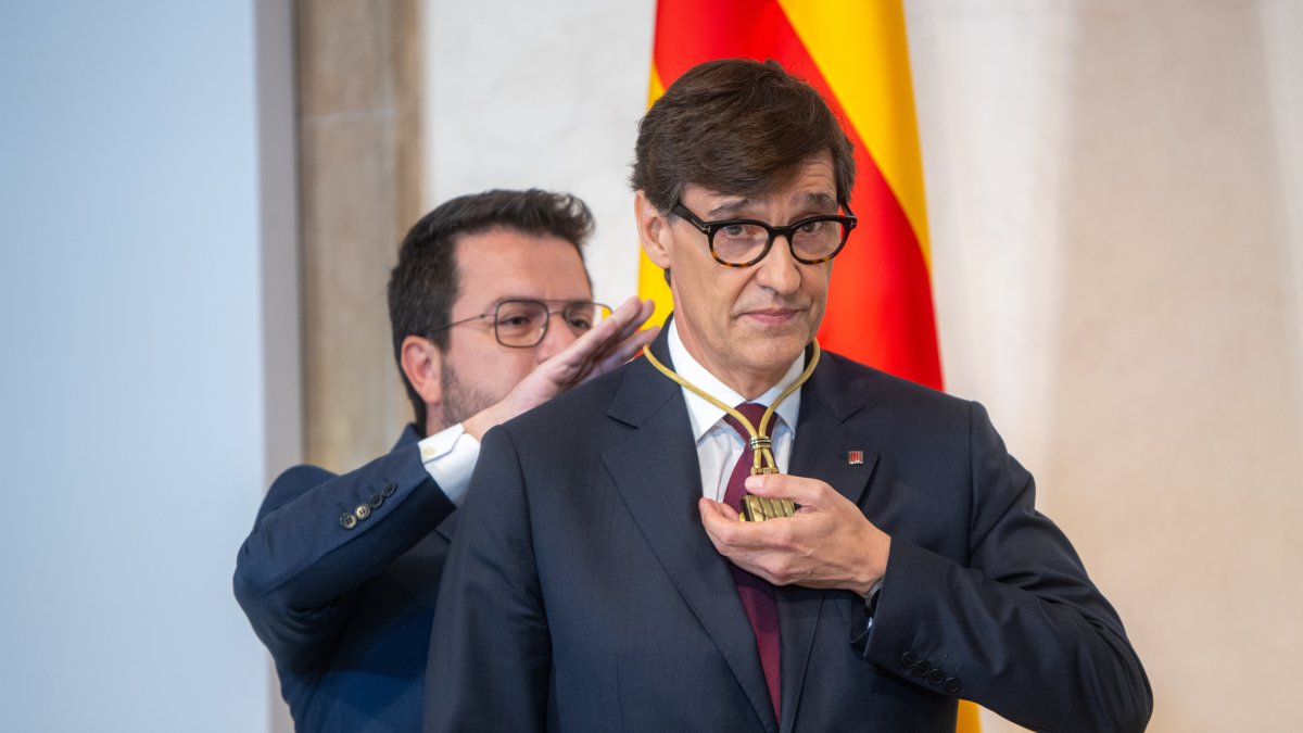 El ya expresidente de la Generalitat, Pere Aragonès, pone la medalla de la presidencia al y el nuevo presidente de Cataluña, Salvador Illa.