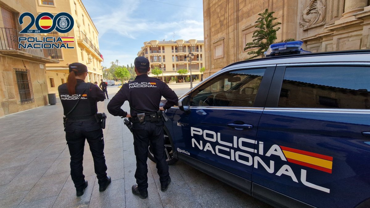 Imagen de agentes y de un coche patrulla de la Policía Nacional