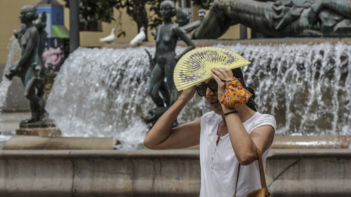 Mujer tapándose del sol con un abanico