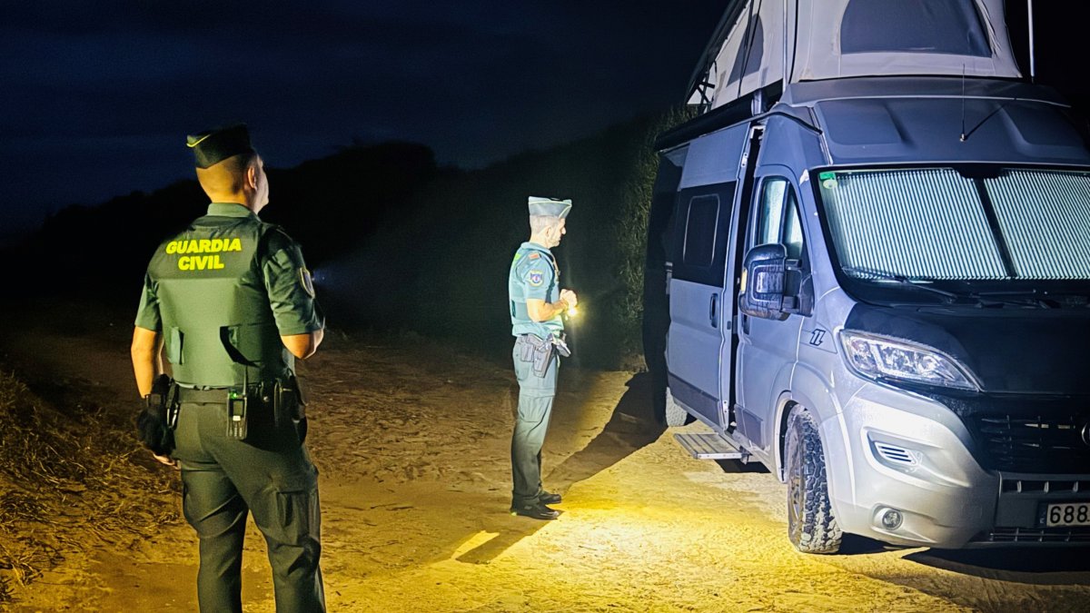 Agentes de la Guardia Civil junto a una de las autocaravanas desalojadas en Tarifa (Cádiz).