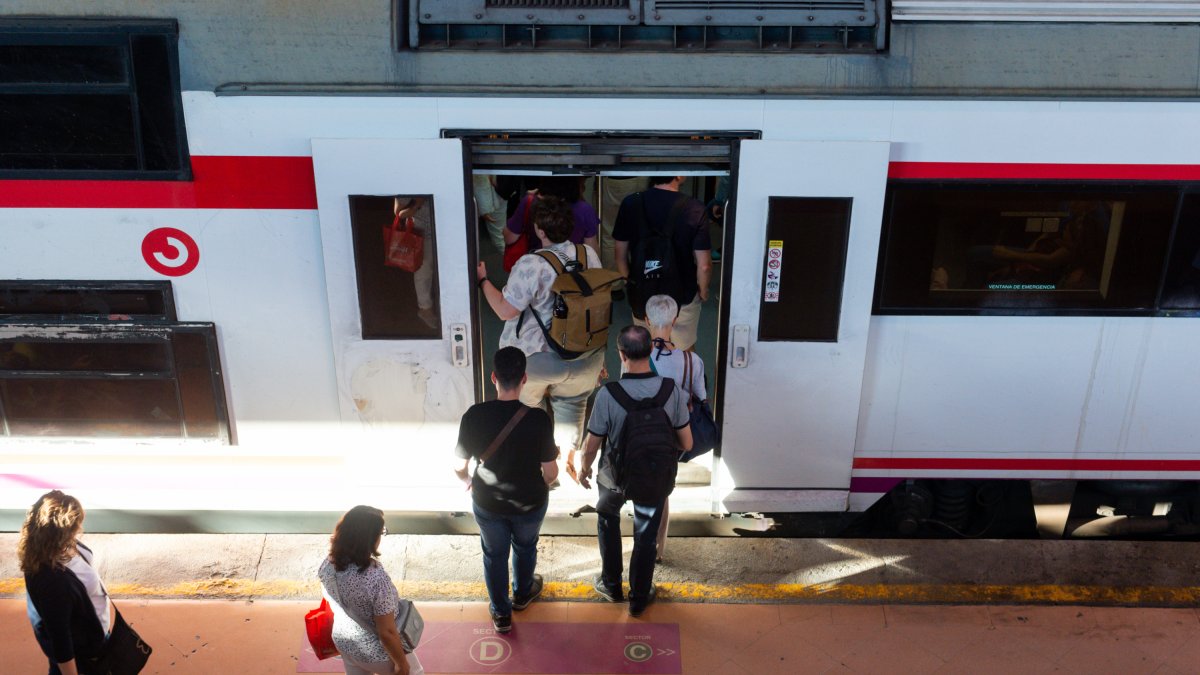 Varias personas a su entrada en un vagón de tren