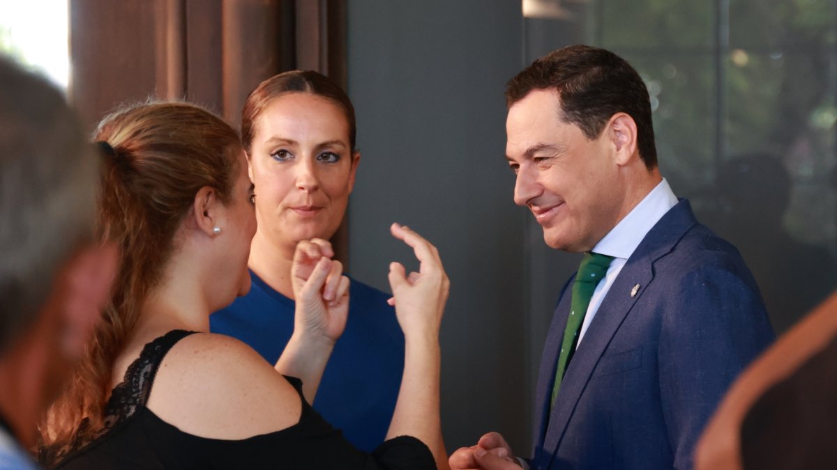 El presidente de la Junta de Andalucía, Juanma Moreno conversa con asistentes a la reunión del Comité Español de Representantes de Personas con Discapacidad (CERMI).