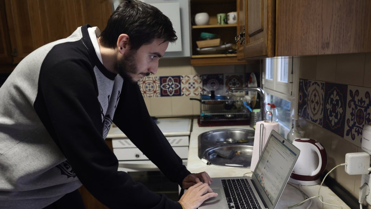 Archivo - Una persona teletrabajando en la cocina de su domicilio.