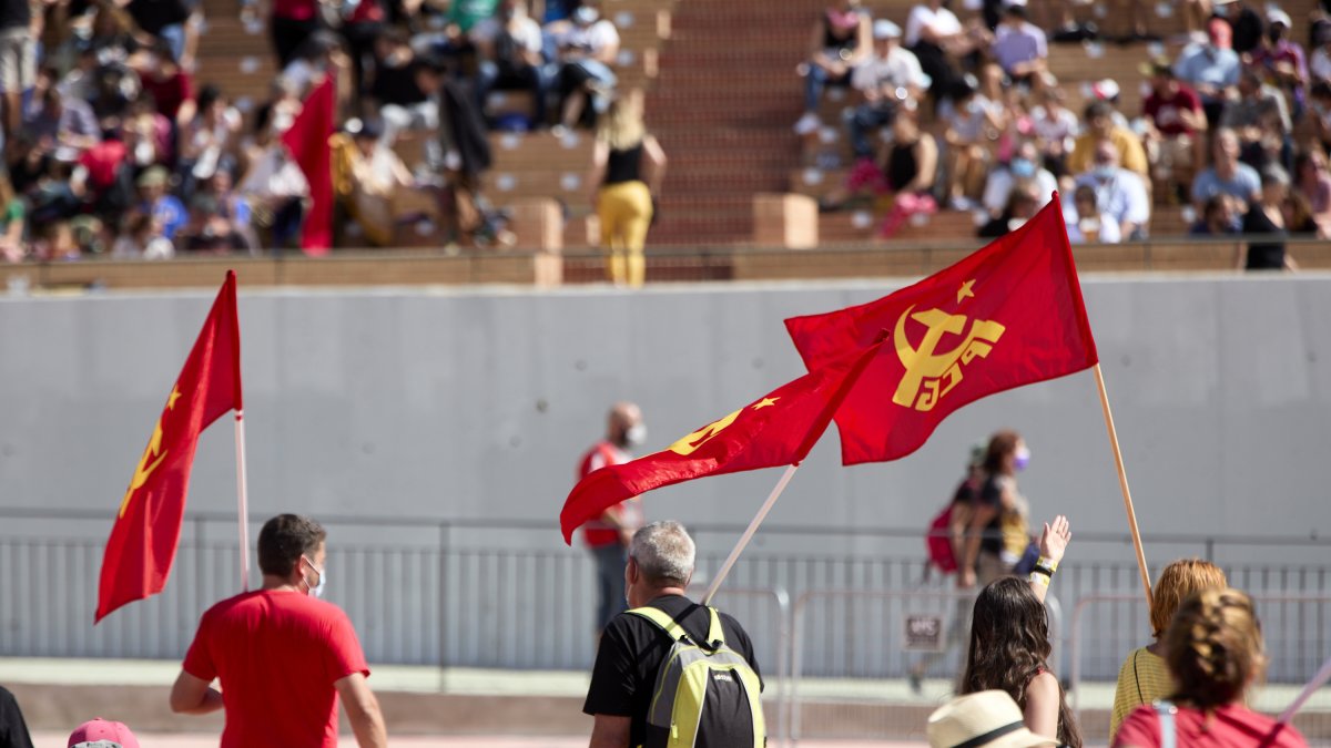 Varias personas sostienen banderas del PCE, en la fiesta del centenario del PCE