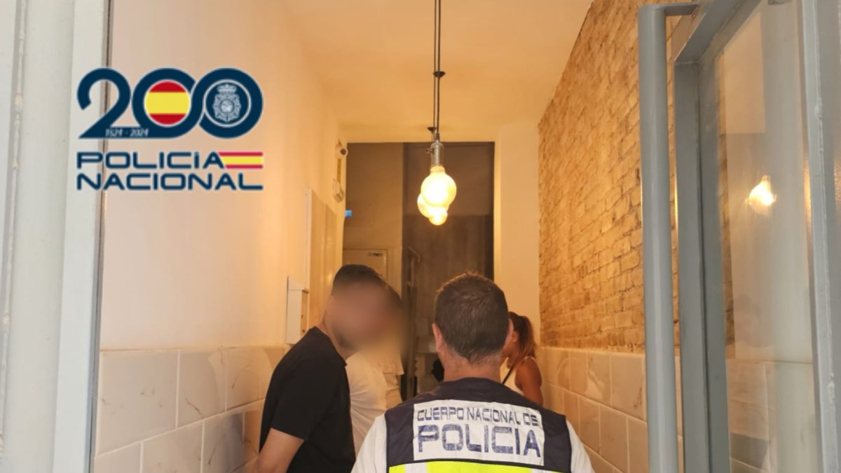 Agente de la Policía Nacional con uno de los detenidos