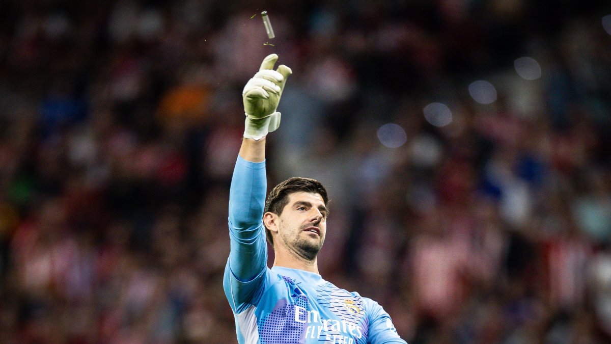 Courtois, recibiendo uno de los objetos que cayó al césped del Metropolitano el pasado domingo.