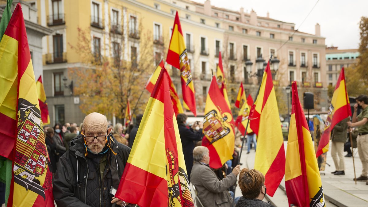 Varias personas sostienen banderas de España en una concentración franquista.