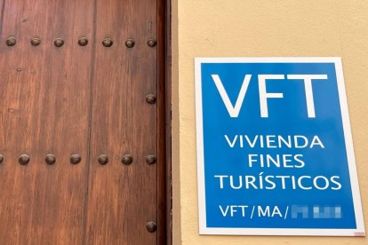 Puerta de una vivienda turística en Málaga con el cartel indicativo de licencia de 'Vivienda con Fines Turísticos'.