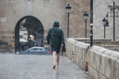 Una persona camina bajo la lluvia