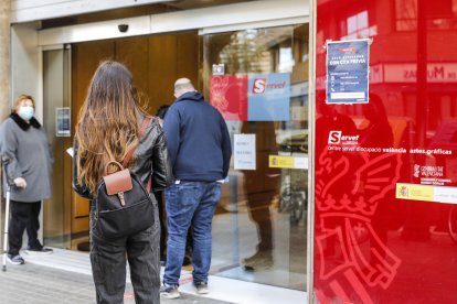 Varias personas con cita previa esperan para entrar en una oficina del SEPE