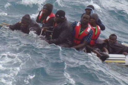 Imagen del rescate de varias personas mientras la  patera en la que navegaban se hunde en el Estrecho de Gibraltar.