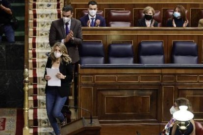 Sánchez aplaude a Díaz al subir a la tribuna a defender su reforma laboral.