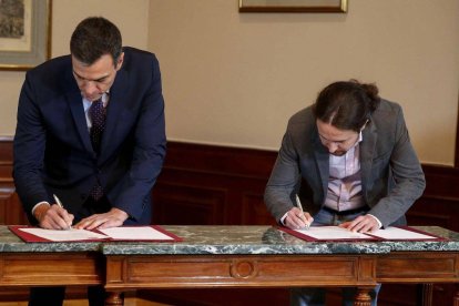 Sánchez e Iglesias firmando su acuerdo de investidura.