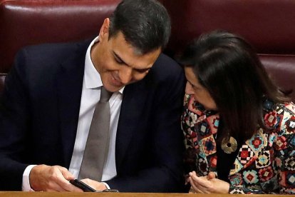 Pedro Sánchez y Margarita Robles ven el móvil