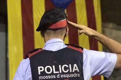 Albert Donaire, líder de los mossos rebeldes, rinde honores a una estelada, símbolo de los independentistas.