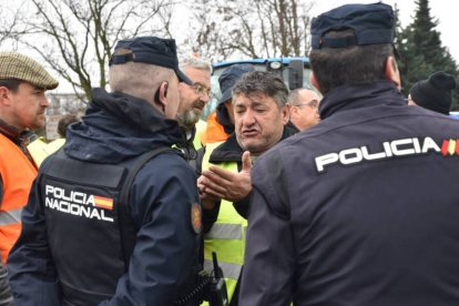 Un grupo de agricultores manifestándose frente a unos Policías