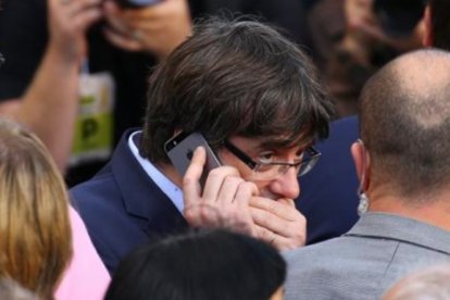 Puigdemont, hablando por teléfono con gesto preocupado.