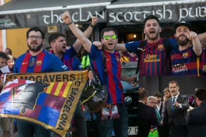 Aficionados del Barça antes del partido, y una imagen del Rey en una visita reciente a la Ciudad Condal