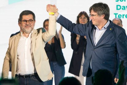 El secretario general de Junts, Jordi Sànchez, y el expresidente de la Generalitat, Carles Puigdemont, se dan la mano durante el Congreso de su partido en Francia