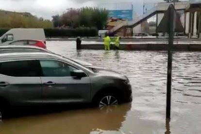 Imagen de operarios municipales colocando las compuertas con el barranco ya desbordado.