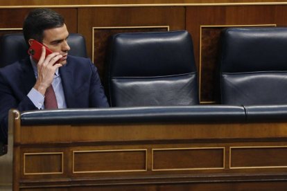 Pedro Sánchez, hablando por su teléfono móvil en su escaño.