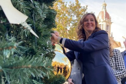 María José Catalá coloca la decoración en el árbol de la plaza del Ayuntamiento