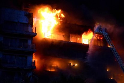 Los bomberos tratan de apagar las llamas de un edificio, en el barrio de Campanar