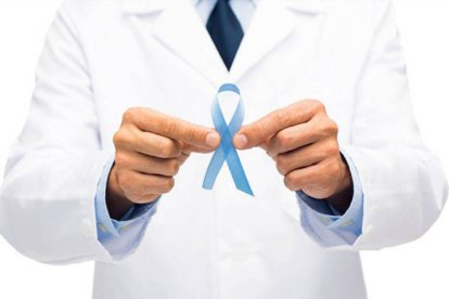 Imagen de un lazo azul, le símbolo del cáncer de próstata, en manos de un médico