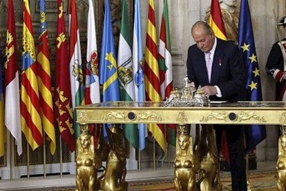 Juan Carlos I firmando su abdicación.