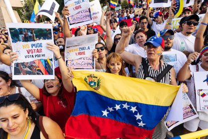 Manifestantes con pancartas durante una protesta en apoyo a la oposición venezolana en Madrid.