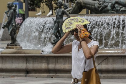 Mujer tapándose del sol con un abanico