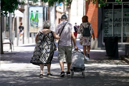 Archivo - Una pareja de ancianos camina por la calle con un carro de compra, a 27 de julio de 2021, en Madrid, (España). La Seguridad Social destinó en el presente mes de julio la cifra récord de 10.202,29 millones de euros al pago de pensiones contributi.