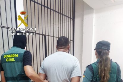 Agentes de la Guardia Civil con uno de los investigados