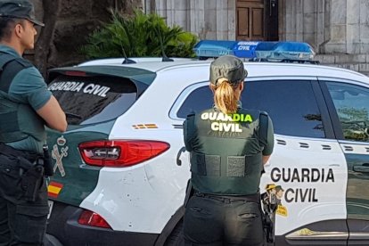 Una agente y un coche de la Guardia Civil