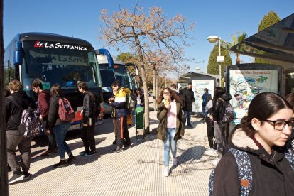 Estudiantes junto a los autobuses universitarios