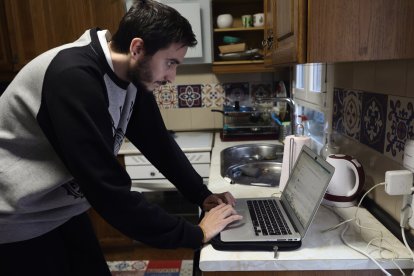 Archivo - Una persona teletrabajando en la cocina de su domicilio.