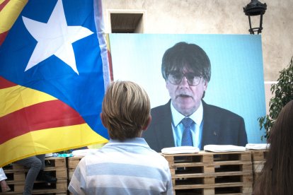 Un niño observa una intervención telemática de Puigdemont