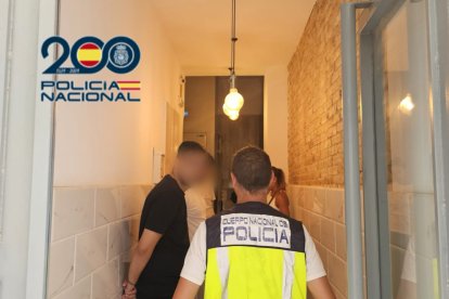 Agente de la Policía Nacional con uno de los detenidos