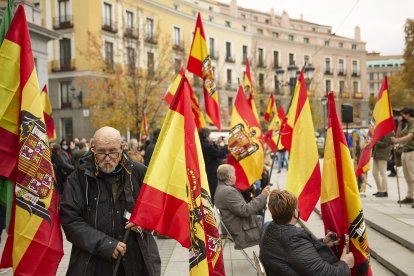 Varias personas sostienen banderas de España en una concentración franquista.