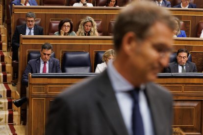 En primer plano el líder del PP, Alberto Núñez Feijóo; y al fondo el presidente del Gobierno, Pedro Sánchez, en el Congreso.