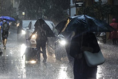 Varias personas andando bajo la lluvia