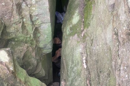 Mujer atrapada entre rocas tratando de recuperar su móvil