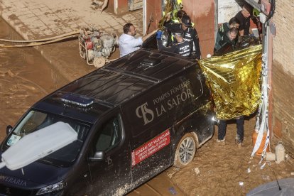 Un furgón de la funeraria sale de un garaje con cadáveres localizados tras el paso de la DANA, en el barrio de la Torre