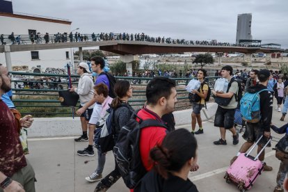 Decenas de personas en el puente que une València con La Torre, donde centenares de personas llegan de Valencia de abastecerse de agua y alimentos mientras otras salen de ayudar